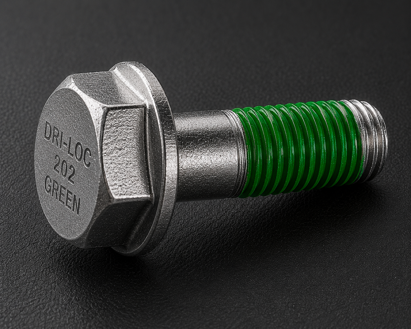 A silver hex bolt with green threading labeled "DRI-LOC 202 GREEN" lies on a black textured surface.